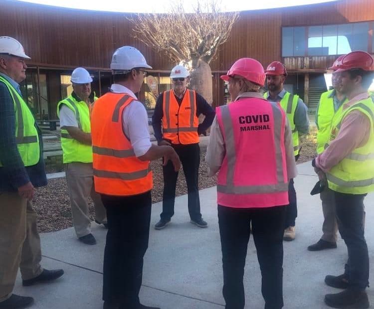 Steven Marshall at Monarto Safari Park's new Visitor Centre. Mr Marshall is talking with a group of workers wearing hard hats and high visibility vests